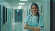 © Viorel Sima - young female doctor in scrubs with stethoscope crossing arms on hallway