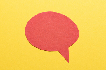 Poster - Red cut out blank paper speech bubble of round shape with copy space for text on yellow background, flat lay top view conceptual backdrop