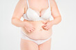 © staras - Tummy tuck, flabby skin with stretch marks on a fat belly, plastic surgery concept on light gray background