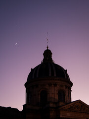 Toit de l'institut de France de nuit, à côté d'un croissant de lune.