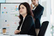 © itchaznong - Businesswoman listening thoughtfully during a corporate presentation.