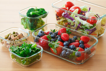 Canvas Print - Healthy vegan food preparations for week in glass containers. Vegetables, nuts, berries in boxes.