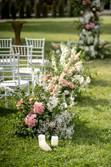 Wall Mural - Wedding ceremony. Very beautiful and stylish wedding arch, decorated with various fresh flowers, standing in the garden.