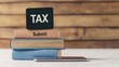 © Adul khotchasri - A stack of books labeled 'TAX' and 'Submit,' with a smartphone beside it, set against a wooden background, symbolizes tax preparation and submission.