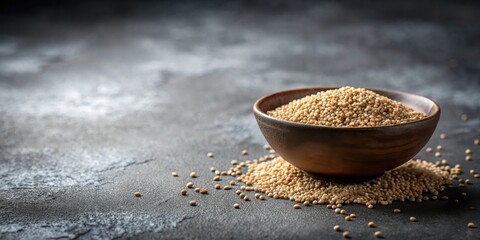 Aufkleber - A rustic bowl filled with small, light beige seeds, spilling onto a dark gray surface.