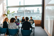 © Maskot - Group of male and female business professionals discussing during meeting in board room at office