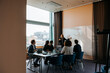 © Maskot - Female business professional brainstorming colleagues in team meeting at office