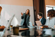 © Maskot - Businesswoman discussing strategies with colleagues sitting on board room
