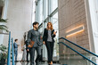 © Maskot - Male and female business professionals talking while moving down from steps at convention center