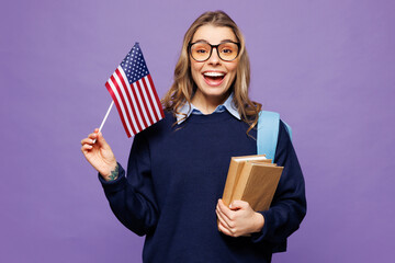 Poster - Young shocked surprised girl student wears blue casual clothes glasses backpack bag hold books American flag isolated on plain pastel light purple background. High school university college concept.