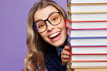 Poster - Close up young smiling happy girl student she wear blue casual clothes glasses hold stack of books look camera isolated on plain pastel light purple background. High school university college concept.