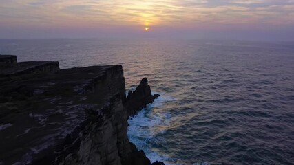 Poster - Sunset over rugged cliffs by the ocean in a serene coastal landscape