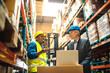© Davor - Warehouse manager and worker discussing logistics in storage facility
