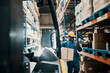 © Davor - Smiling male worker using smartphone and carrying box in large warehouse