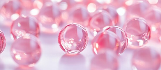 Poster - Transparent pink glass marbles scattered on a light surface with reflections and highlights Copy Space
