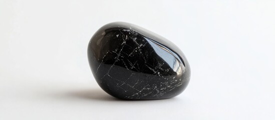 Poster - Polished black stone with smooth surface and visible sheen on white background, suitable for natural dÃ©cor and wellness aesthetics Copy Space