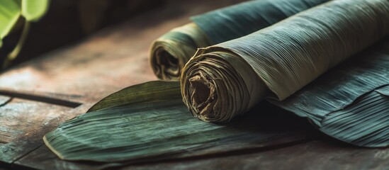 Poster - rolled dried leaves on a wooden surface with natural lighting showing texture and color variations. 