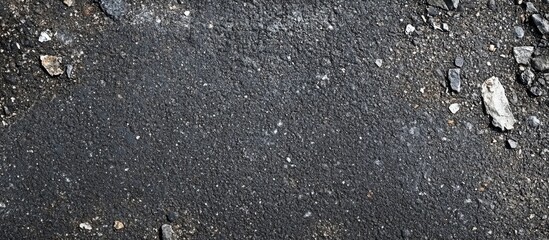Poster - Dark asphalt texture with small stones and debris providing a rough surface pattern suitable for backgrounds Copy Space