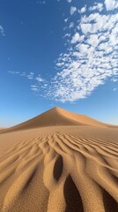 Poster - Golden sand stretches endlessly beneath a bright blue sky, with soft clouds drifting above. Footprints weave through the rippled surface, hinting at past wanderings in this serene landscape