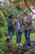 © Caia Image - Family with adult son looking at plants in garden