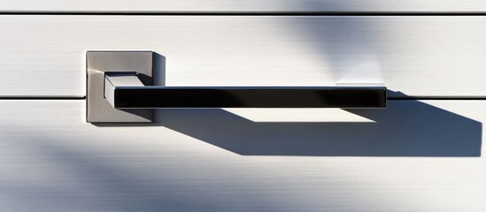 Wall Mural - Modern door handle with geometric design on silver brushed metal surface casting a shadow Copy Space