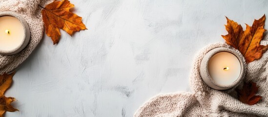 Poster - Cozy autumn flat lay with candles, knitted fabric, and dry leaves on textured background Copy Space