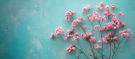Poster - Pink flowers on a turquoise textured background with leaves and space for text Copy Space