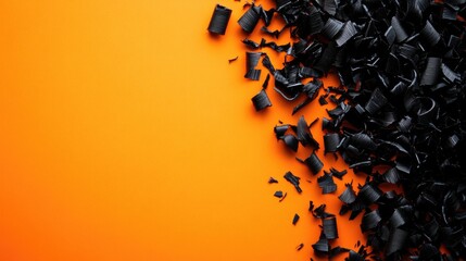 Poster - Black plastic shavings on bright orange background with clear space for text or design elements