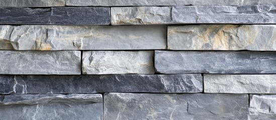 Poster - Gray and black stacked stone wall texture background with varied shapes and sizes of stone pieces Copy Space