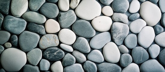 Poster - Textured arrangement of smooth river stones in various shades of gray and white perfect for backgrounds with Copy Space.