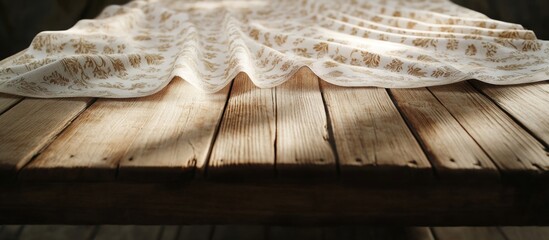 Poster - Textured white tablecloth draped over rustic wooden table under soft natural light with emphasis on fabric folds and grain patterns. Copy Space