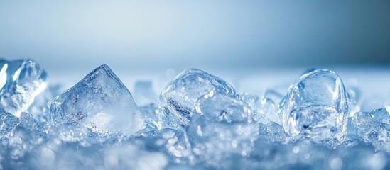 Poster - Close-up of clear ice cubes and crushed ice on a textured surface with a soft blue background and ample copy space.