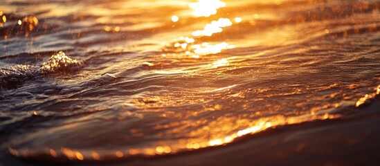 Poster - Close-up view of ocean waves reflecting golden sunlight during sunset with natural bokeh effect and smooth water surface Copy Space