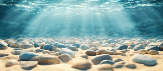 Aufkleber - Underwater view of pebbles on the sandy ocean floor with sun rays illuminating the scene Copy Space