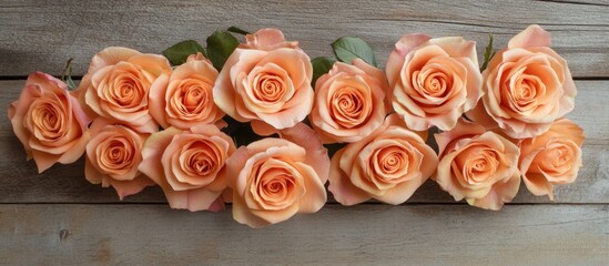 Canvas Print - Peach roses arrangement on wooden background with leaves and visible texture featuring copy space for text