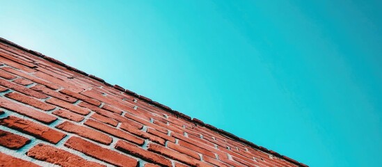 Poster - Textured red brick wall against a clear blue sky with ample copy space for text placement.