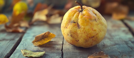 Poster - Yellow quince fruit on rustic wooden table surrounded by autumn leaves with copy space for text.