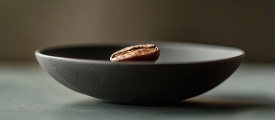 Aufkleber - Coffee bean on a textured black plate against a minimalist background with soft lighting and copy space for text