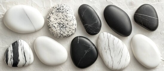 Aufkleber - Smooth polished black and white stones arranged on a textured surface with contrasting colors and patterns Copy Space