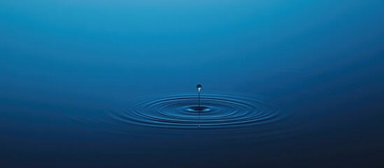 Poster - water droplet creating ripples in a calm blue surface with copy space for text