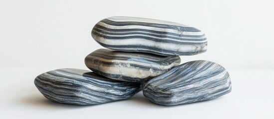 Poster - Stacked smooth black and white striped pebbles on a light background with copy space for text