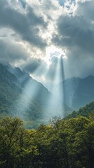 Aufkleber - Sunlight pours through gaps in the clouds, casting ethereal beams over lush green valleys and rugged mountain peaks. Nature radiates tranquility and wonder in this serene location