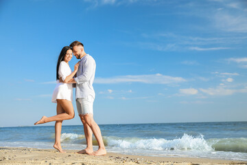 Wall Mural - Happy young couple at beach on sunny day