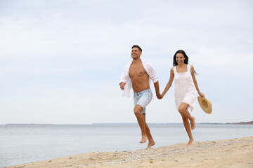 Wall Mural - Lovely couple having fun on beautiful beach. Space for text