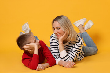 Canvas Print - Happy mother and son on orange background