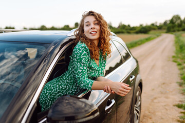 Wall Mural - Woman tourist on road, enjoying window view.  Summer trip. Lifestyle, travel, tourism, nature, active life.