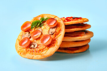 Wall Mural - Different tasty mini pizzas on blue background