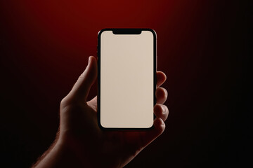 Poster - Hand holding smartphone against dark background with warm lighting