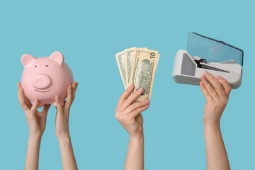 Wall Mural - Female hands with piggy bank, money and cash counting machine on color background, closeup