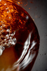 Wall Mural - Golden drink is poured into the glass, creating beautiful waves and splashes.